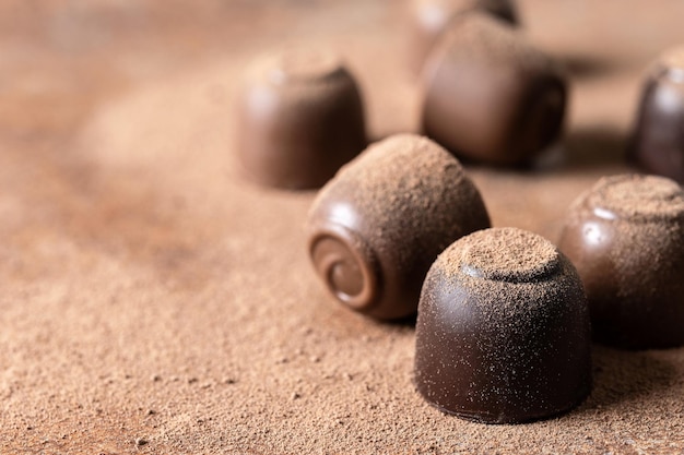 Chocolate bonbons and cocoa powder background Close up