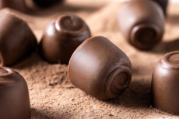 Chocolate bonbons and cocoa powder isolated on white background