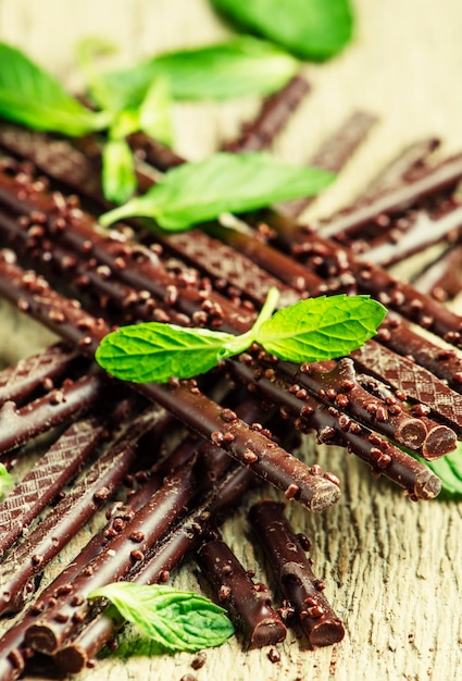 Chocolate branches on old wooden table selective focus