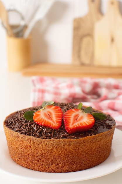 Photo chocolate brigadeiro cake with strawberries in a counter top in the kitchen