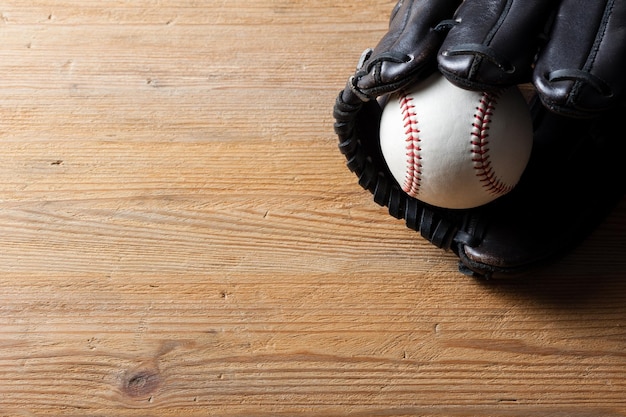 Chocolate brown baseball glove with baseball on wood board sport concept