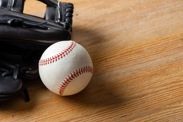 Chocolate brown baseball glove with baseball on wood board