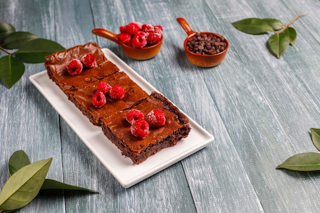 Chocolate brownie cake dessert slices with raspberries and spices,top view