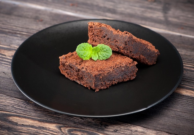 Chocolate brownie cake on a plate wooden dark background