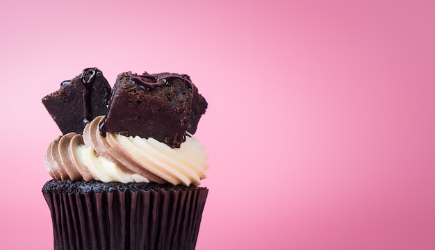 Chocolate brownie cupcake muffin on pink background