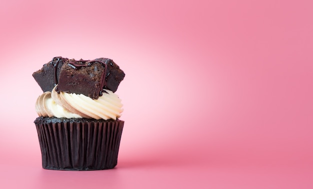 Chocolate brownie cupcake on pink copy space background