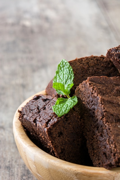 Chocolate brownie portion on wooden table