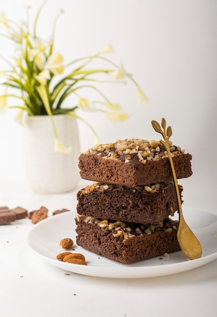 chocolate brownie with nuts on white plate and white background in different angles