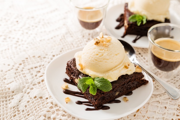 Photo chocolate brownie with vanilla ice cream, nuts and mint