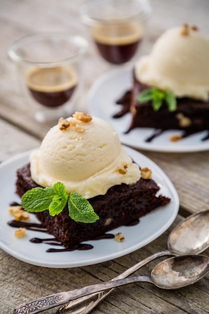 Photo chocolate brownie with vanilla ice cream, nuts and mint