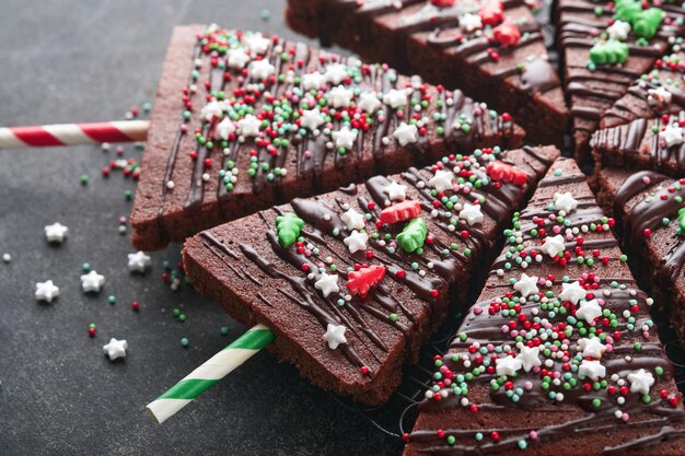Chocolate brownies Christmas tree with chocolate icing and festive sprinkles on stone table Christmas food ideas sweet homemade Christmas holidays pastry concept Holiday cooking concept Top view