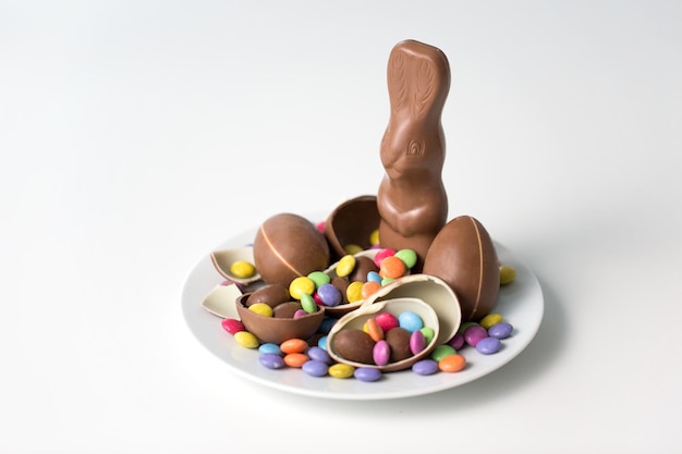 chocolate bunny eggs and candies on white plate