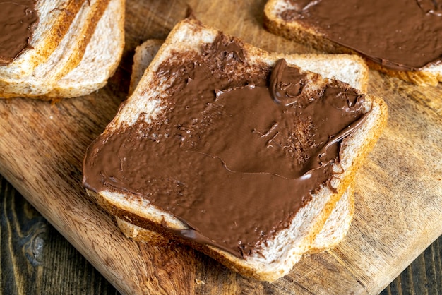 朝食を作りながらパンにチョコレートバターを塗る