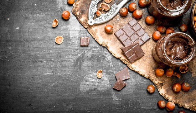 Foto burro al cioccolato con nocciole su una lavagna nera