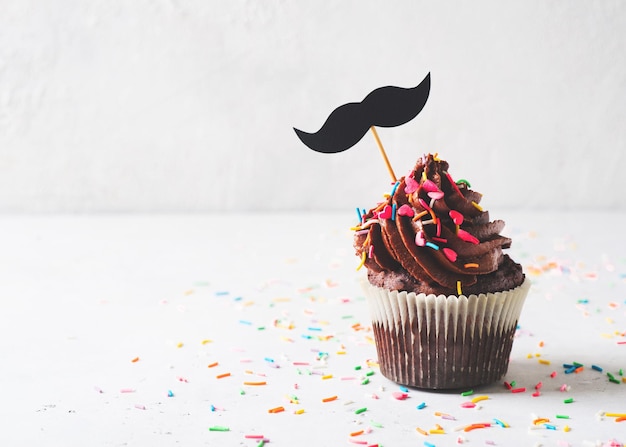Chocolate cacao cupcakes with sprinkles and mustache fathers day concept