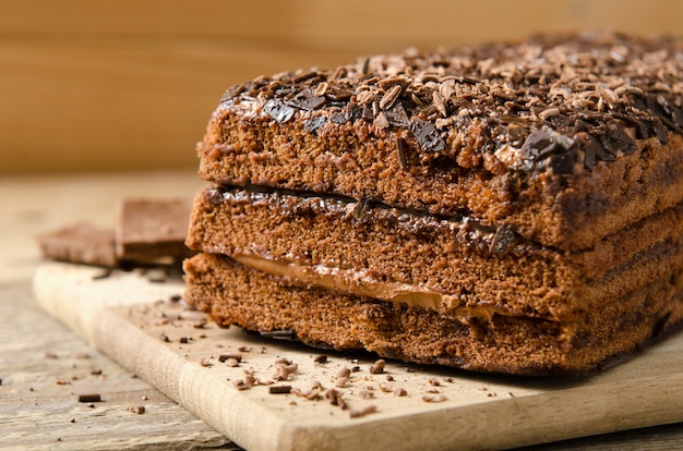 초코 케이크. 초콜릿 바 나무 배경에 초콜릿 파우더 비스킷 디저트