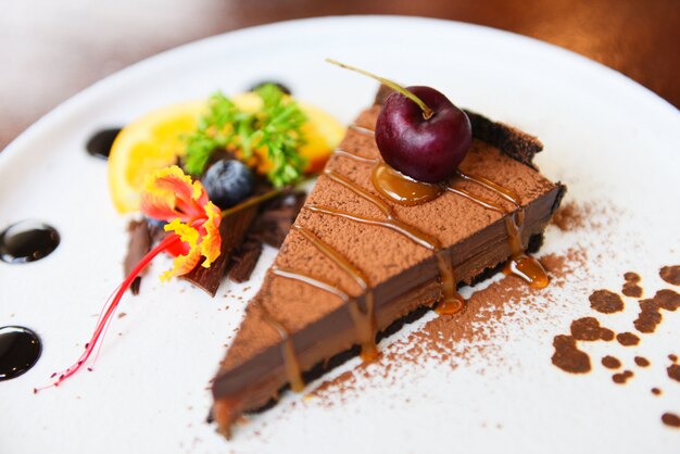 Chocolate cake caramel with cherry and fruit on white plate