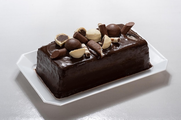 chocolate cake decorated with bonbons on a wooden background