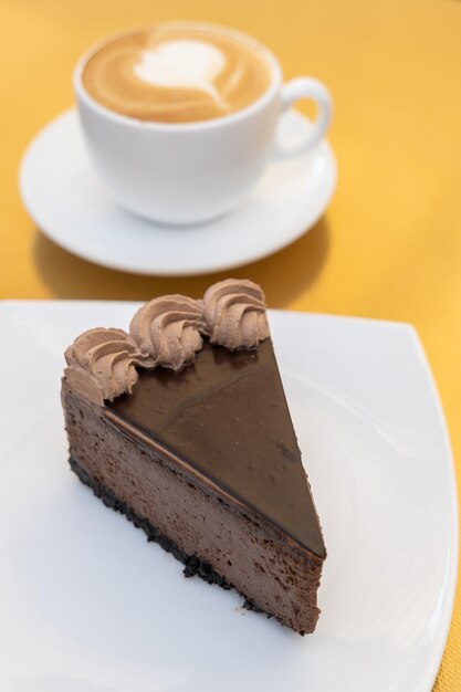 Chocolate cake on golden table with a coffee cup