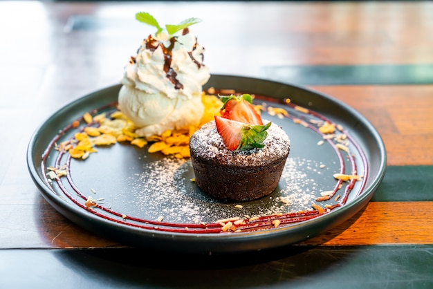 ブラックプレートにストロベリーとバニラのアイスクリームとチョコレートケーキの溶岩