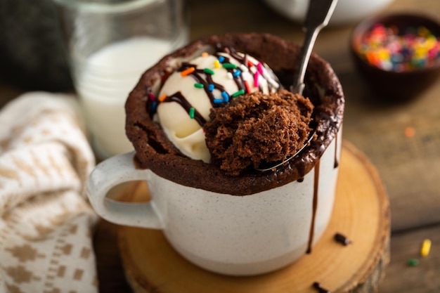 Foto torta al cioccolato in una tazza con gelato e spruzzate