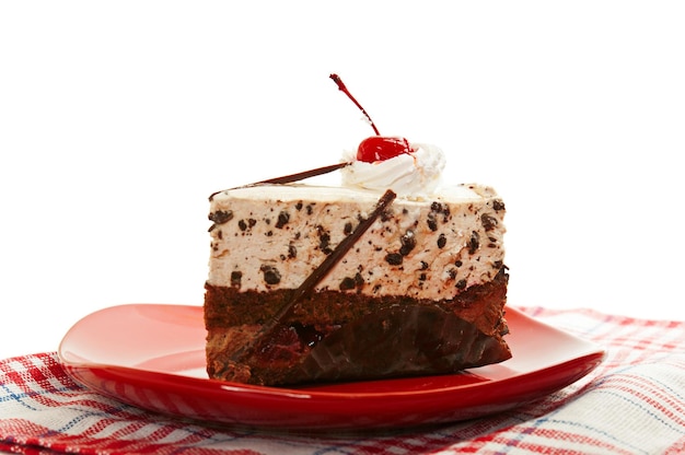 Chocolate cake on red dish with cherry isolated