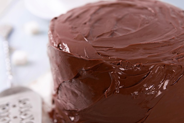 Chocolate cake with blade on a wooden table background macro view