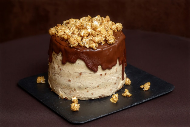 Chocolate cake with caramel and popcorn, close up