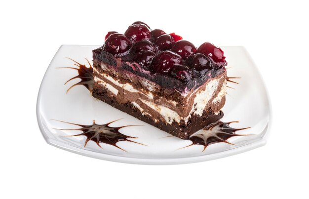 Chocolate cake with cherry on top on a white background