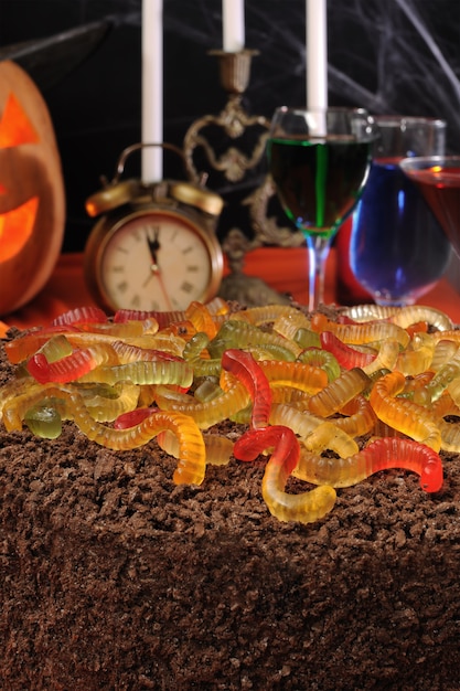 Chocolate cake with gelatin worms on the festive table in honor of Halloween