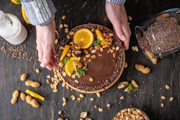 Chocolate cake with orange, cacao, mint leaves, peanuts and nuts