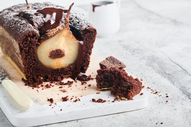 Chocolate cake with pears baked inside Chocolate pear cake or dark chocolate bundt cake with pear on light gray table at home Home cooking and baking recipes concept Selective focus