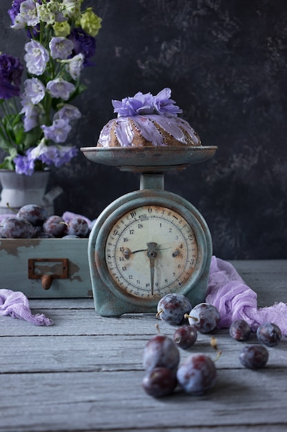 Chocolate cake with plums and lilac flowers