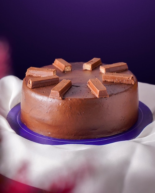 Foto torta al cioccolato con una barretta di cioccolato su uno sfondo viola