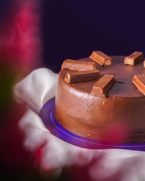 Foto torta al cioccolato con una barretta di cioccolato su uno sfondo viola