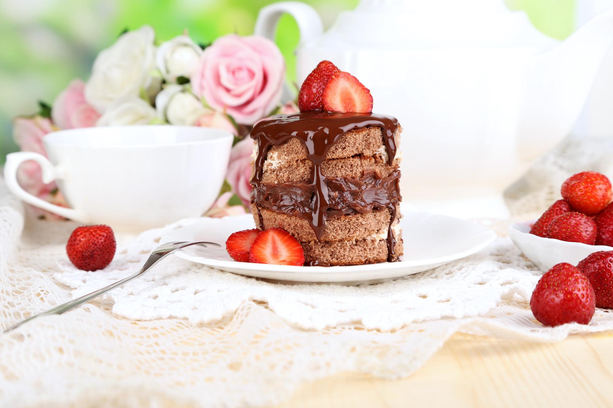 自然な背景の木製テーブルにイチゴとチョコレートケーキ