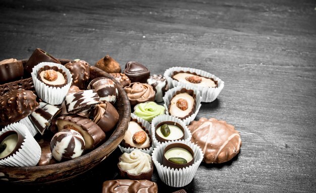 Chocolate candies in a bowl. On the black chalkboard.