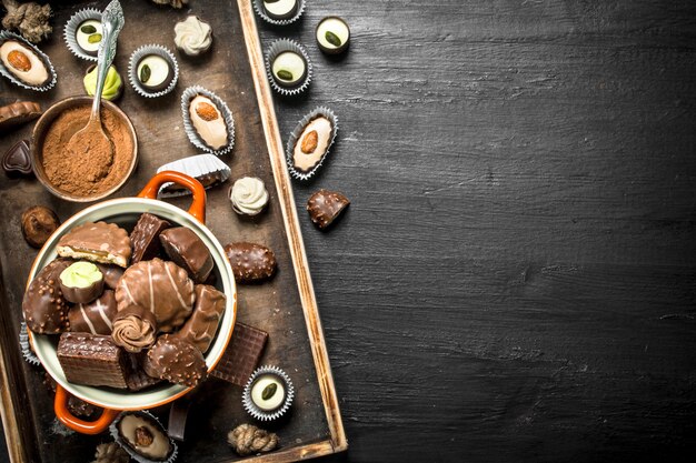 Chocolate candies in a bowl. On the black chalkboard.