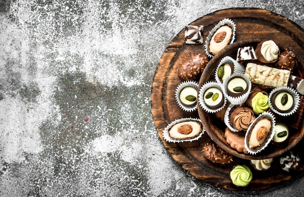 Chocolate candies in a bowl. On a rustic background.