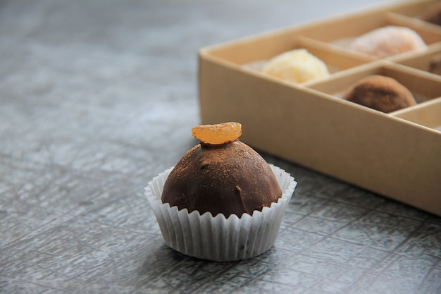 Chocolate candies in a box are on a gray background