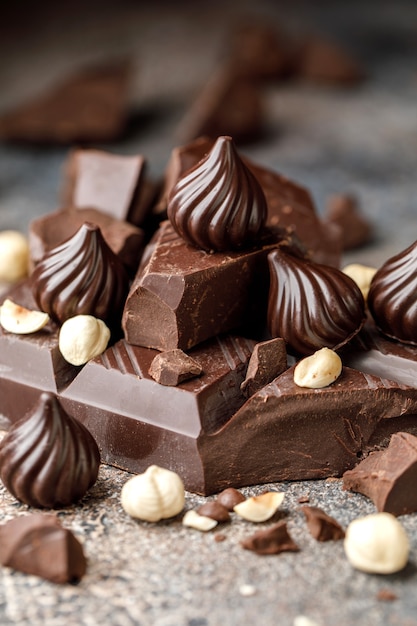 Caramelle al cioccolato su sfondo marrone i pezzi di cioccolato rotto