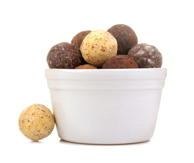 Chocolate candies. candies of different chocolate in a white bowl on a white isolated background. close-up