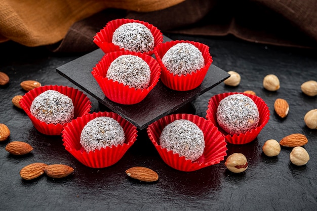 Chocolate candies covered with coconut Delicious homemade dessert on a dark background