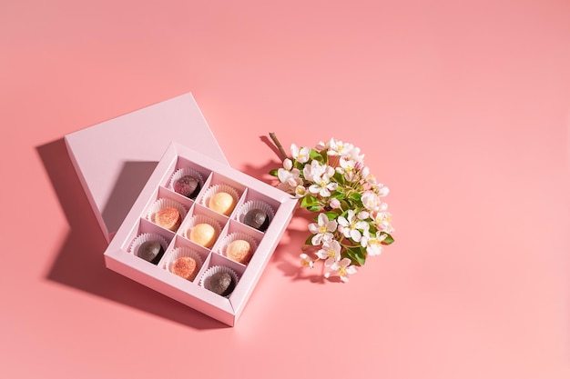 Chocolate candies in a festive box on a pink background Holiday concept Minimalism food dessert Horizontal frame