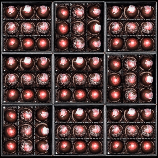 Шоколадные конфеты в подарочных коробках. Ассорти конфет кондитерских изделий в их подарочных коробках. Набор красочных шоколадных конфет. Вид сверху, флай лежал.