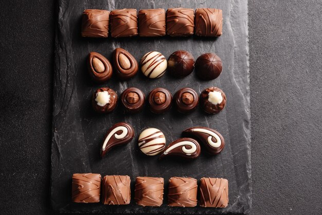 Шоколадные конфеты с различными начинками сладкая еда фон смешивает и сочетает набор различных конфет
