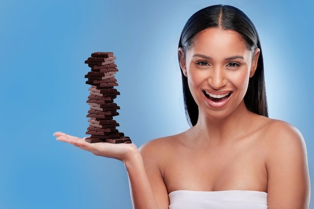 Chocolate candy and happy with portrait of woman in studio for diet sweets and sugar cocoa food and