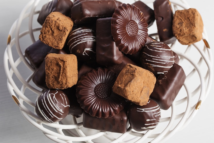 Photo chocolate candy on plate on white table
