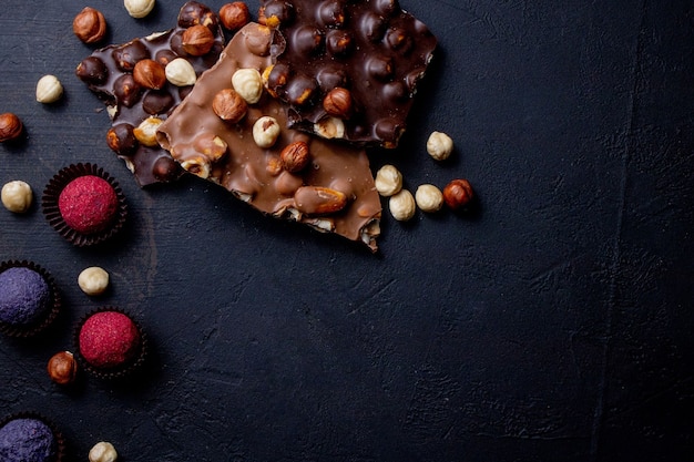 チョコレートのかけらと暗闇の中で飛んでいるココアパウダーとチョコレートキャンディトリュフ。