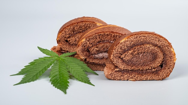 Chocolate cannabis roll with THC and CBD extract cookies with marijuana on gray background